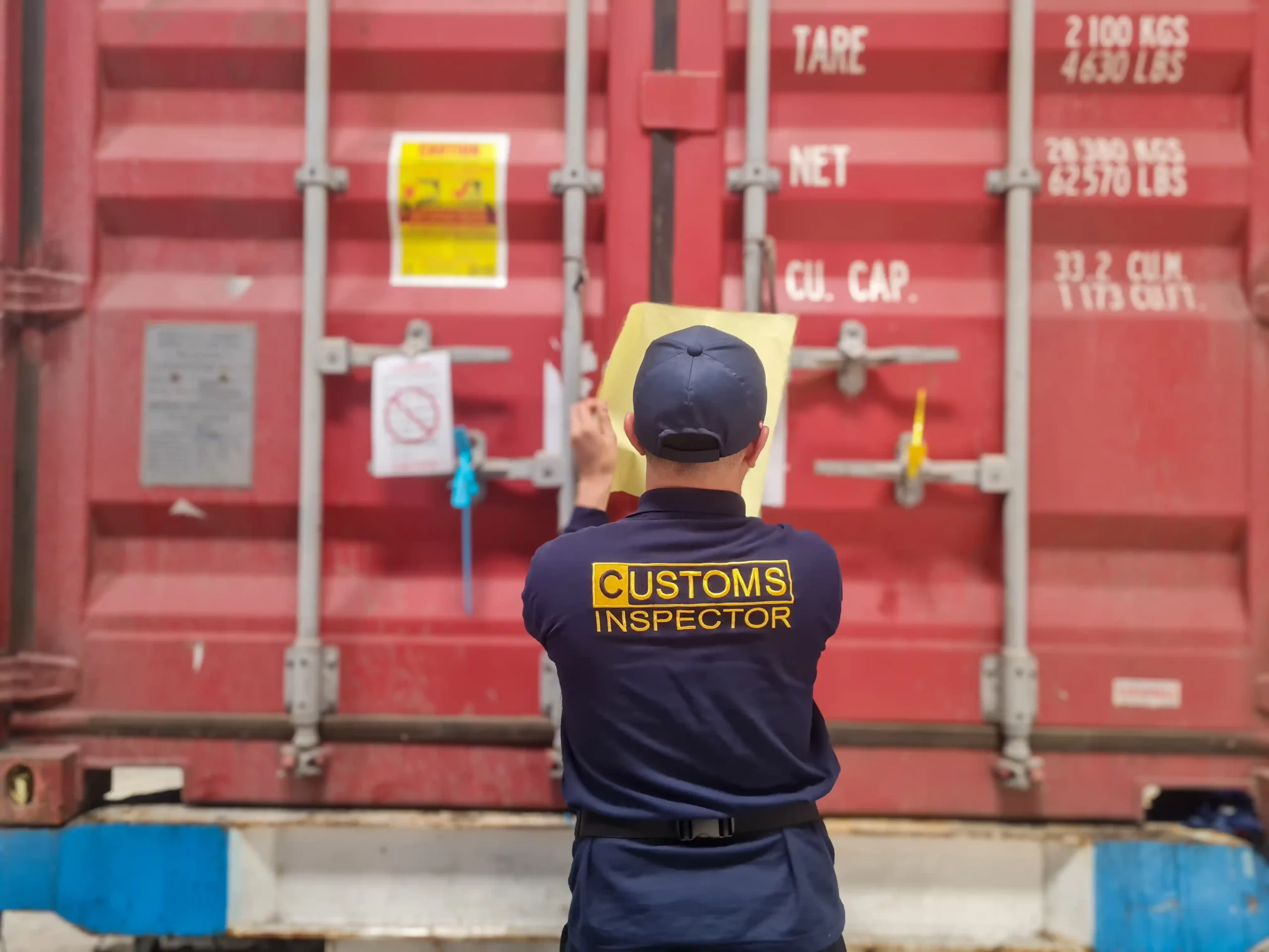 Customs inspector checking documentation on a shipping container